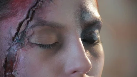 Makeup artist makes wax plastic makeup in form of bloody wound on face of girl Stock Footage 105600074
