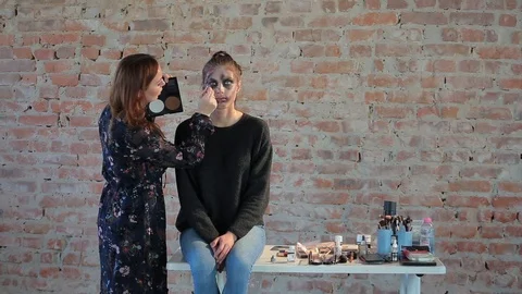 Makeup artist makes wax plastic makeup in form of bloody wound on face of girl Video stock 105600092
