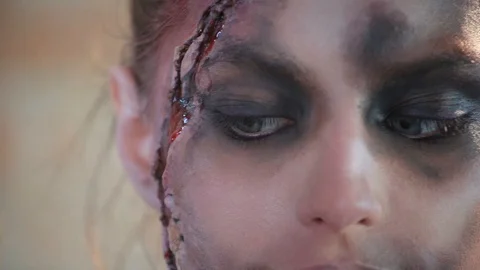 Makeup artist makes wax plastic makeup in form of bloody wound on face of girl Stock Footage 105600116