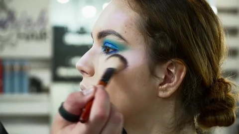 Makeup artist making beautiful face art for a brunette woman Stock Footage 76572494
