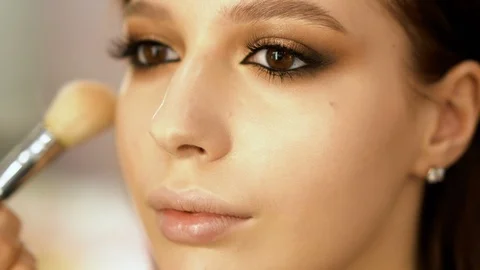 Makeup artist making eye-makeup for young model 4k Stock Footage 111380336