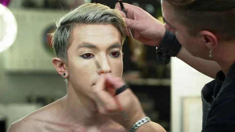 Makeup artist making face art for a young man closeup Stock Footage 76577883