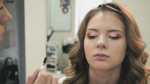 Makeup artist making make-up for a young model Stockbeeldmateriaal 64861829