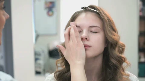 Makeup artist making make-up for a young model Stock Footage 66415490
