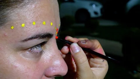 Makeup artist painting flower patterns on caucasian middle age woman. Stock Footage 123714321