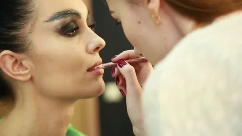 Makeup artist paints lips Stock Footage 74350148