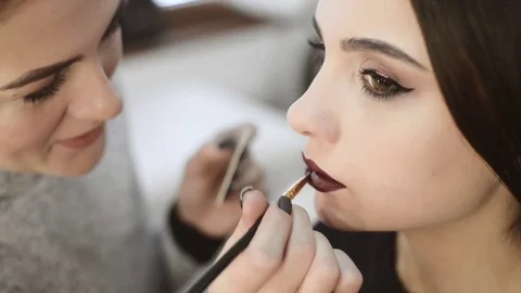 Makeup artist paints a model lips,makeup, professional, slow motion Stock Footage 70663023