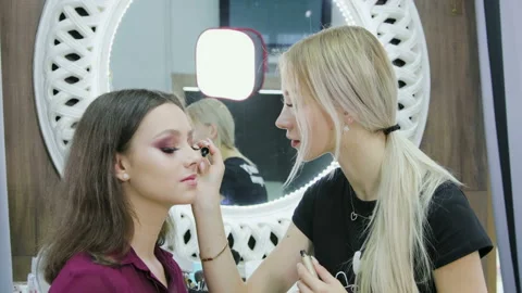 Makeup artist performs eyelash coloring on a beautiful model in a beauty salon Stock Footage 112641192