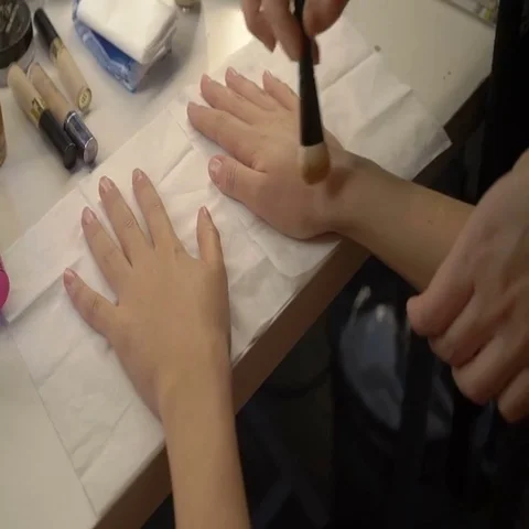 Makeup artist prepares the model hands for the photo shooting Stock Footage 69488113