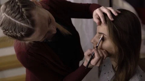 Makeup artist puts a shadow on the model Stockbeeldmateriaal 85756246