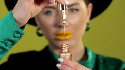 Makeup artist shows liquid bronzer-highlighter close up Stock Footage 231056339