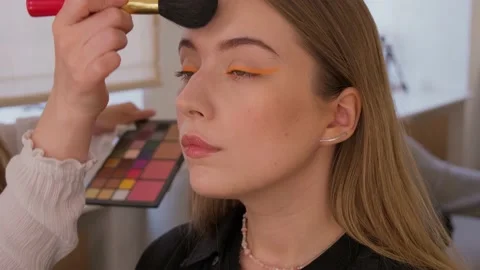 Makeup artist uses brushes and applies foundation to the model's face. Stock Footage 199839430