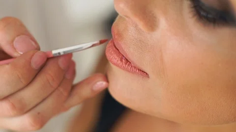 Makeup artist using brush for application lipstick on lips beautiful woman Stock Footage 91654928