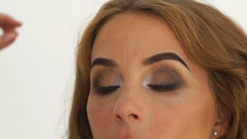 Makeup artist using cosmetic brush for draws arrows in makeup eyes. Visagiste Stock Footage 91490791