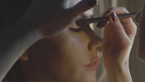 Makeup artist using cosmetics brush for applying eye shadow on eyelid Stock Footage 91286196
