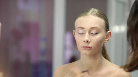 Makeup artist at work applying eye shadow on model's eyelids  Stock Footage 67319400