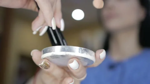 Makeup artist's hands shake off excess powder from makeup powder. Stock Footage 105909769