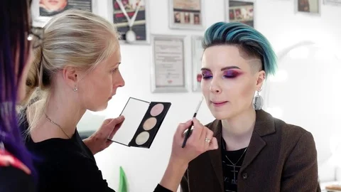Makeup artists at work making smoky eyes on beautiful model with blue hair Stock Footage 80759777