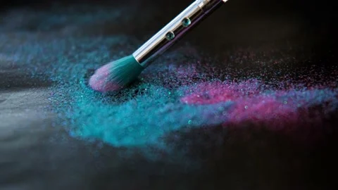 Makeup brush and shiny pink and blue sequins on a black background. Stock Footage 165603471