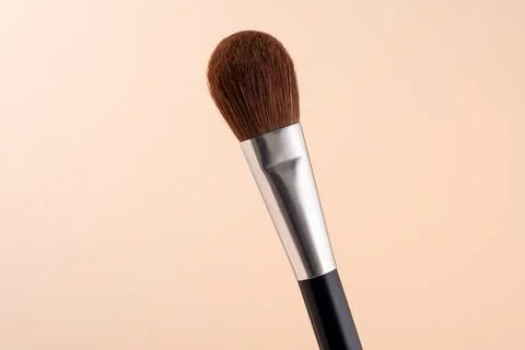 Makeup brush for applying face powder isolated on pastel beige background Stock Photos