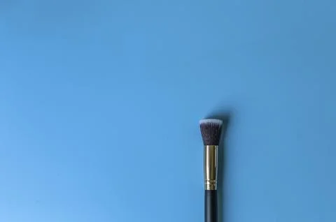 Makeup brush on a blue background Stock Photos