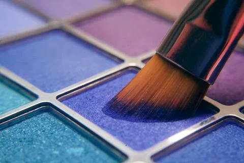 Makeup brush on blue shadows. Bright shadows for the summer. Macro frame of s Stock Photos