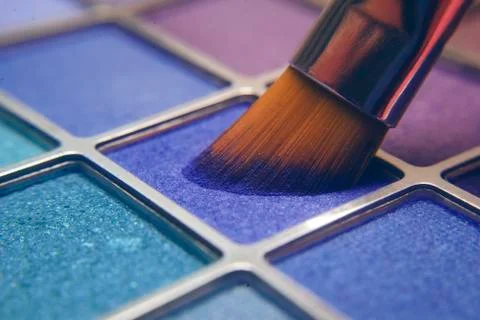 Makeup brush on blue shadows. Bright shadows for the summer. Macro frame of s Stock Photos