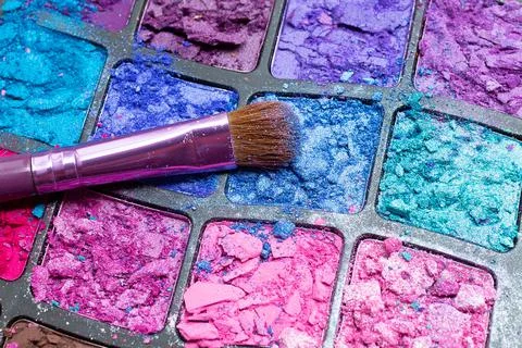 Makeup brush close-up on the background of broken eye shadows. Cosmetic brush Stock Photos