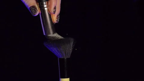 Makeup brush with colored blue and yellow powder on black background Slow Motion Stock Footage 228691096