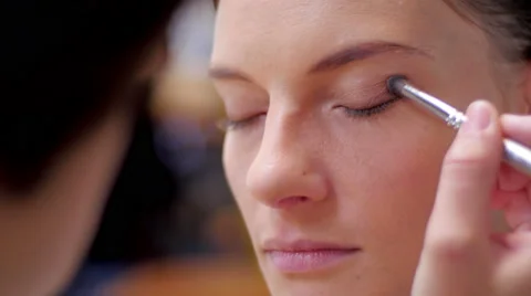 Makeup brush on eye and people in background closeup Stock-Footage 59730299