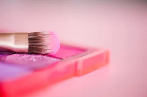 Makeup brush on eye shadow palette closeup. Selective focus. Stock Photos