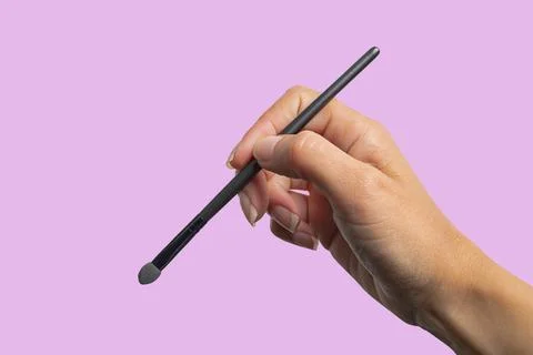 Makeup brush held by a hand Stock Photos