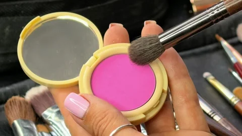 Makeup brush picks up pink blush from a cosmetic compact in close up Stock Footage 341940412