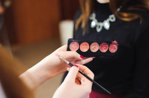 Makeup brush, products in hands, close up photo Stock Photos