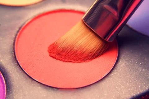 Makeup brush on red shadows. Bright shadows for the summer. Macro frame of sh Stock Photos