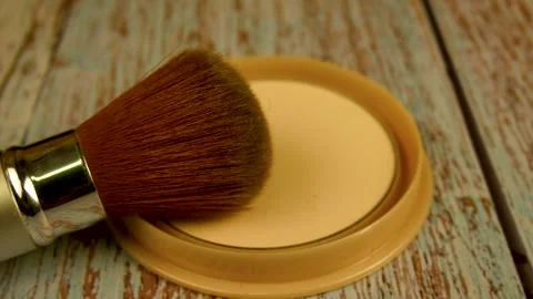 The makeup brush rests on an open box of powder. Female makeup concept. Stock Footage 258676965
