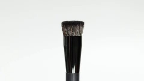 Makeup brush rotates on a white background. Makeup brush. Close-up. Stock Footage 128191359