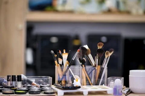Makeup brushes and cosmetics arranged on a table in a beauty studio for app.. Stock Photos