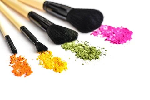 Makeup brushes and crushed eyeshadow Stock Photos