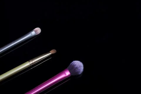 Makeup brushes on black background. Cosmetics, fashion, beauty, glamour. Acce Stock Photos