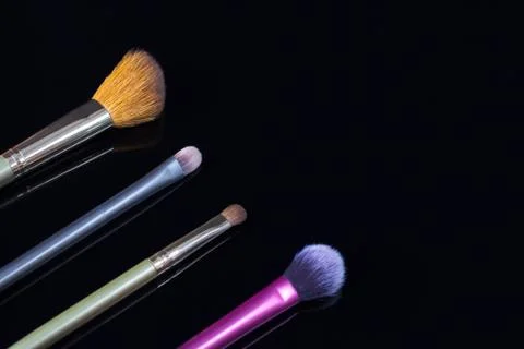 Makeup brushes on black background. Cosmetics, fashion, beauty, glamour. Acce Stock Photos