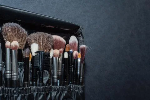 Makeup brushes on a black background, with a place to insert text, Stock Photos