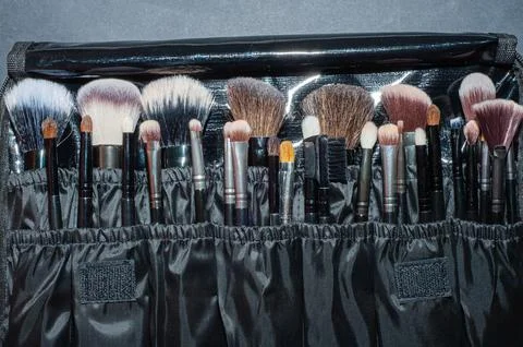 Makeup brushes on a black background, with a place to insert text, Stock Photos
