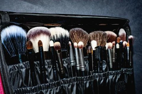 Makeup brushes on a black background, with a place to insert text, Stock Photos
