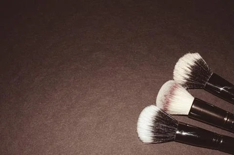 Makeup brushes on a black background, with a place to insert text, Stock Photos