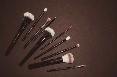 Makeup brushes on a black background, with a place to insert text, Stock Photos