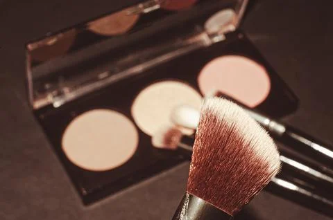 Makeup brushes on a black background, with a place to insert text, Stock Photos
