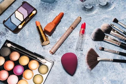 Makeup brushes, decorative cosmetics, false eyelashes on a blue background. the Stock Photos