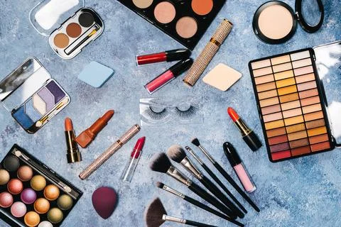 Makeup brushes, decorative cosmetics, false eyelashes on a blue background. the Stock Photos