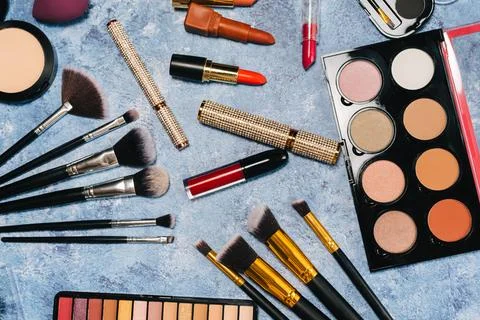 Makeup brushes, decorative cosmetics, false eyelashes on a blue background. the Stock Photos